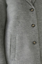 Load image into Gallery viewer, Close-up of a gray wool-blend coat with dark buttons and a side pocket, showing fabric texture and part of the lapel.
