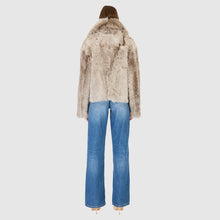 Load image into Gallery viewer, A model shown from the back wearing a light brown and beige faux fur jacket with wide-leg blue jeans, set against a solid light gray background.