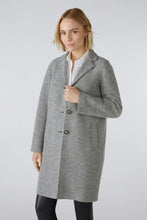 Load image into Gallery viewer, A woman modeling a light gray wool-blend coat over a white collared shirt and black leggings, photographed against a plain light gray studio background.
