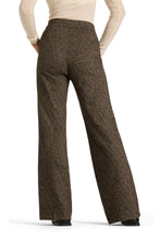 Load image into Gallery viewer, A person shown from the back wearing high-waisted, wide-leg trousers in a brown and beige textured tweed pattern, paired with a cream long-sleeve top and black shoes, against a plain white background.
