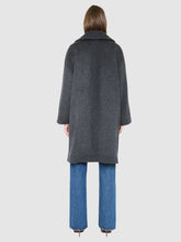 Load image into Gallery viewer, A model shown from the back wearing a dark gray wool-blend coat over blue wide-leg jeans, photographed against a solid light gray background.
