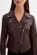 Load image into Gallery viewer, A close-up of a model wearing a dark brown faux leather moto jacket with silver-tone snap and zipper details.
