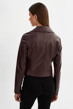 Load image into Gallery viewer, A woman shown from the back wearing a cropped, dark brown faux-leather jacket and black pants against a plain white studio background.
