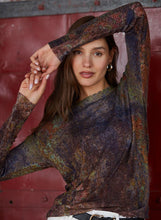 Load image into Gallery viewer, Woman holding a patterned shawl over her head against a red background
